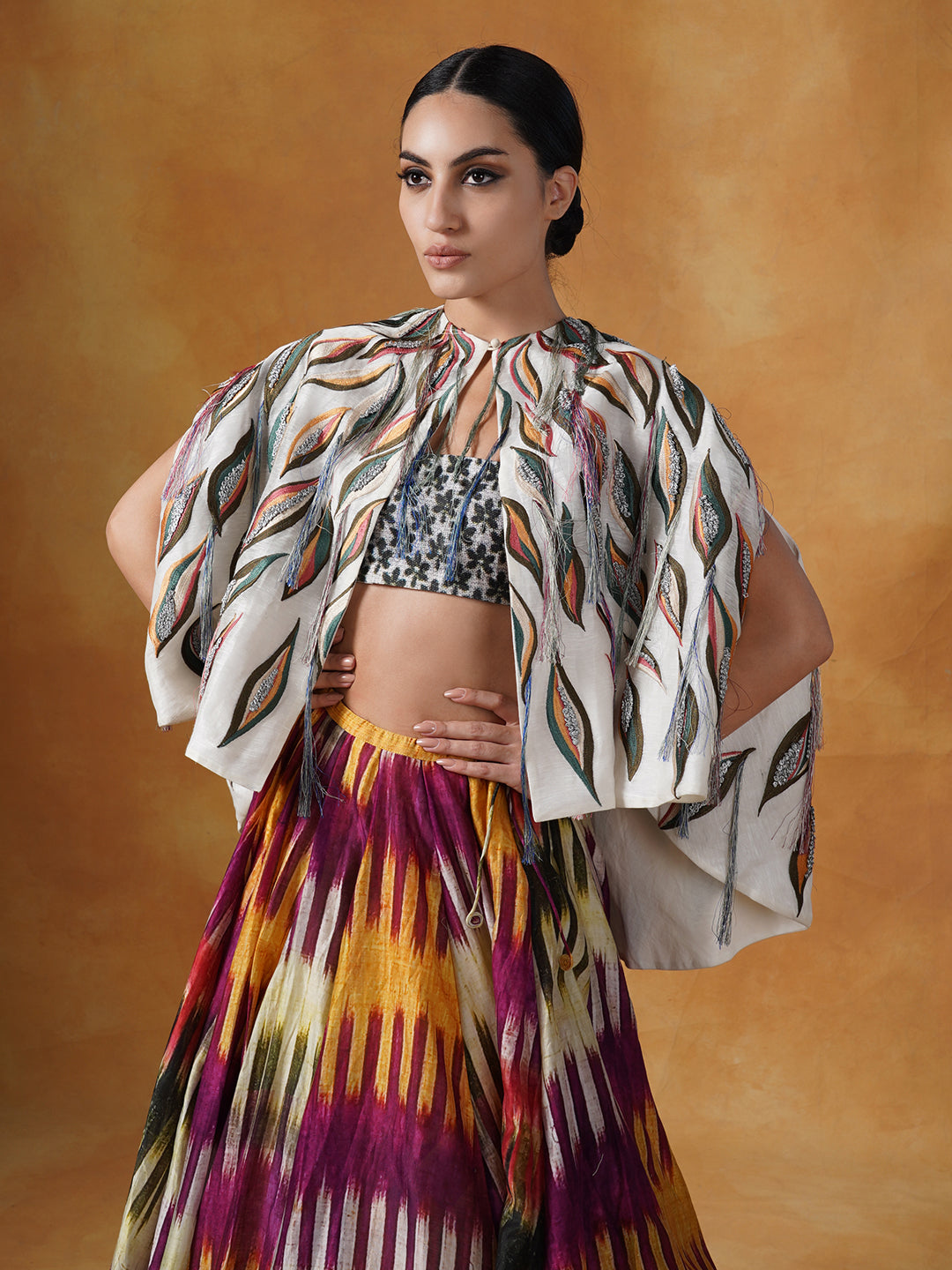 printed cotton silk skirt topped with an off-white cape style waist jacket covered with patchwork with a bustier inside