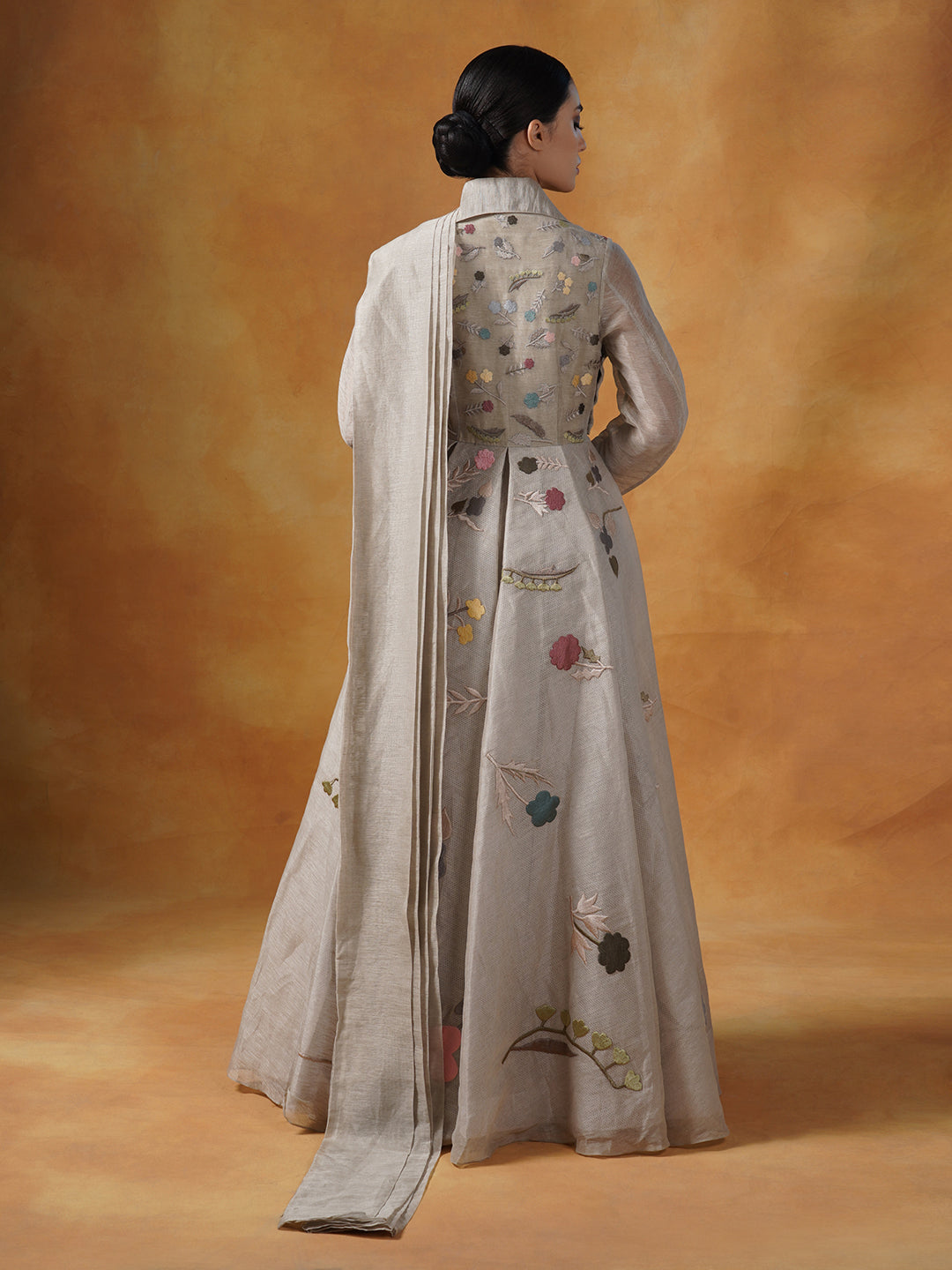 Embroidered A-line linen silk gown which has a collared neck with a pallu that is attached at the waist.