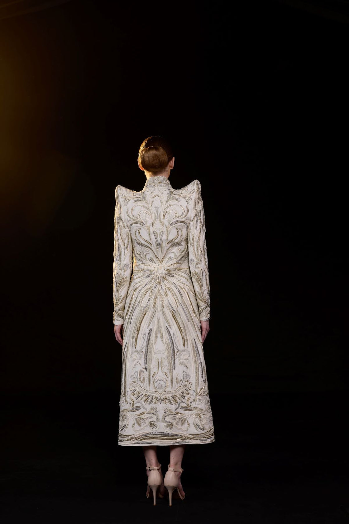 A sophisticated midi dress features a high neckline and long sleeve.
