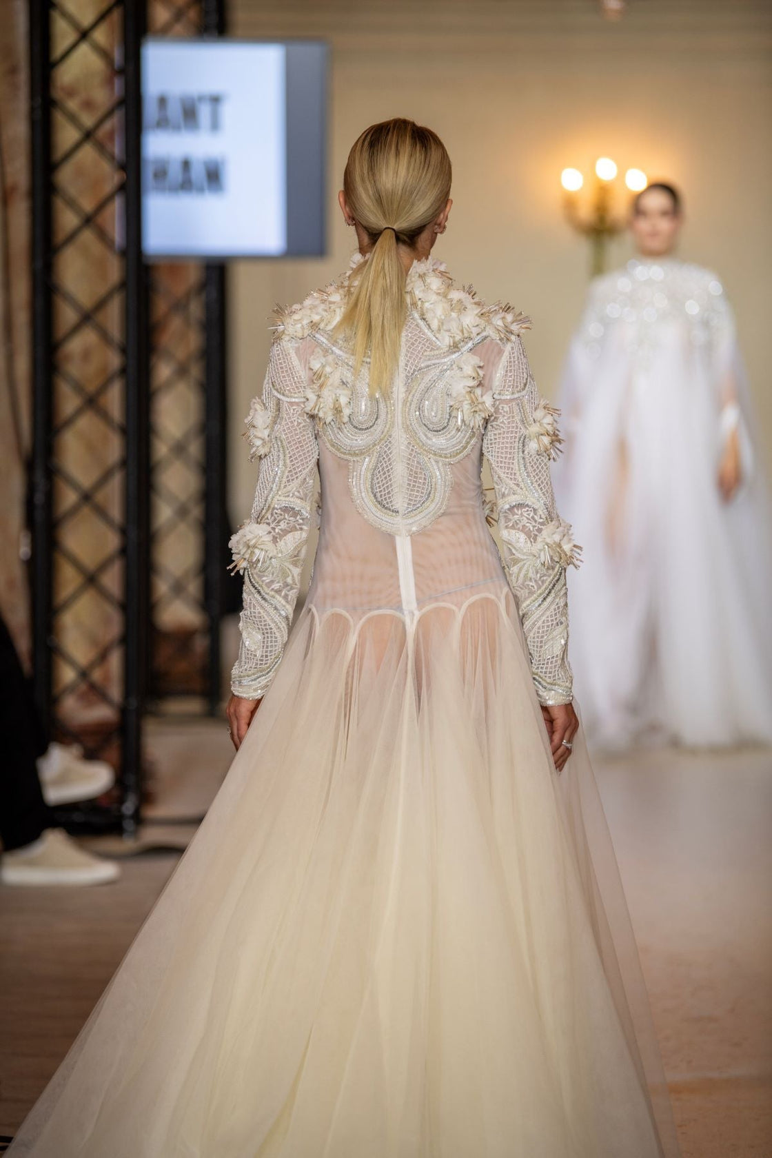 A white  floor length gown with 3d work details & zero neck line.