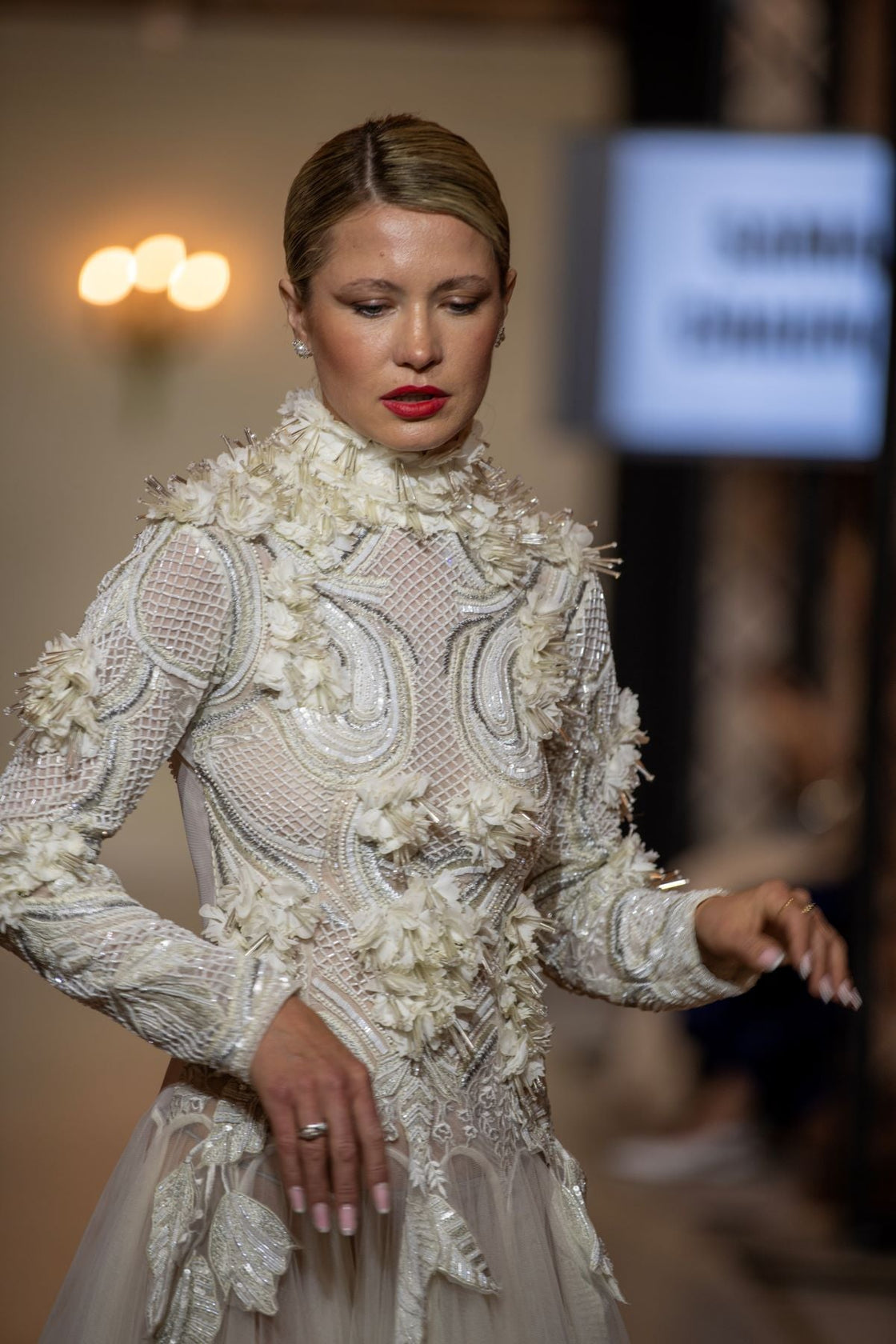 A white  floor length gown with 3d work details & zero neck line.