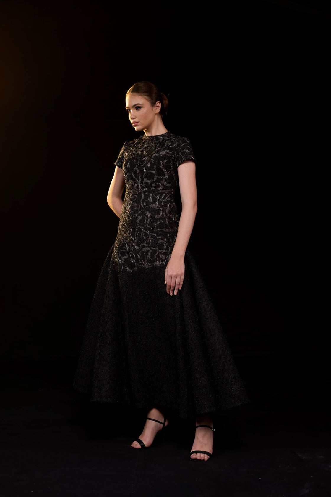 Elegant black gown featuring intricate tonal embroidery.