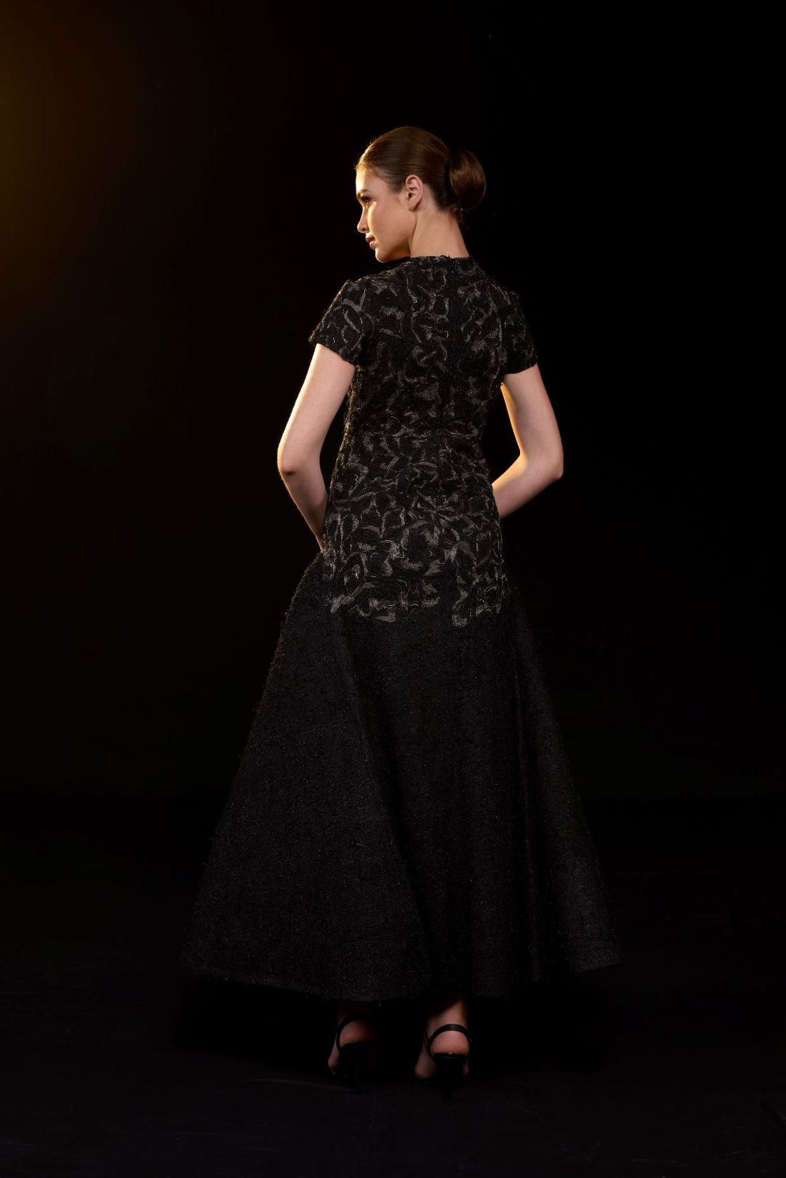 Elegant black gown featuring intricate tonal embroidery.