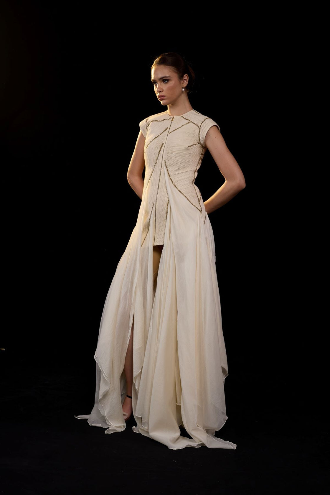 Ivory structured gown with a sculpted bodice and flowing layered panels.
