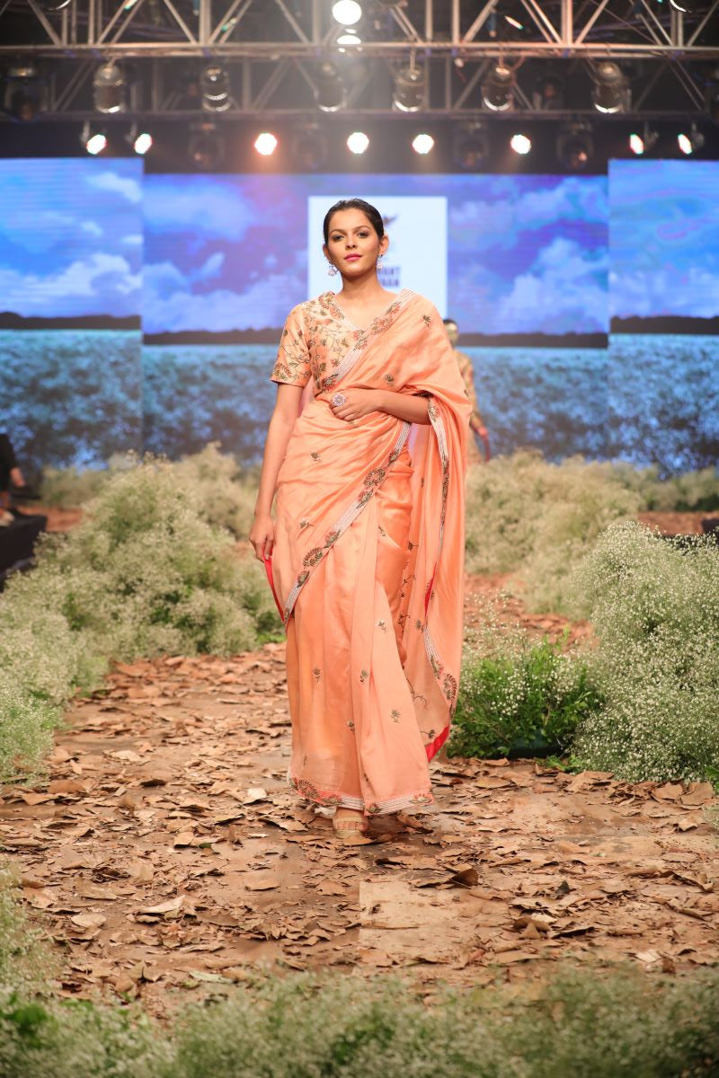 Peach Cotton silk saree and blouse that are embroidered in zari.