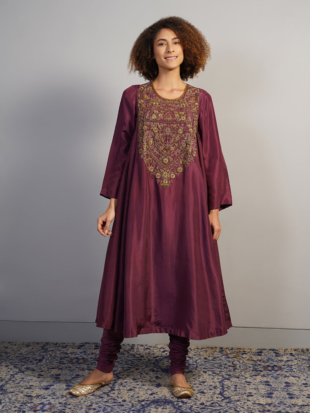 A beautiful deep wine A-line, round neck kurta set with gathers on the sides and intricate gold zardosi embroidery