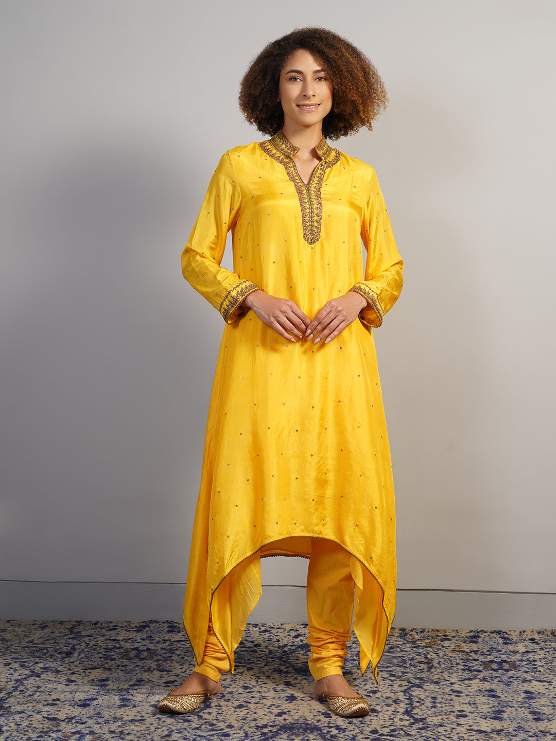 An alluring yellow silk suit set with extended sides is decorated with hand zardosi embroidery