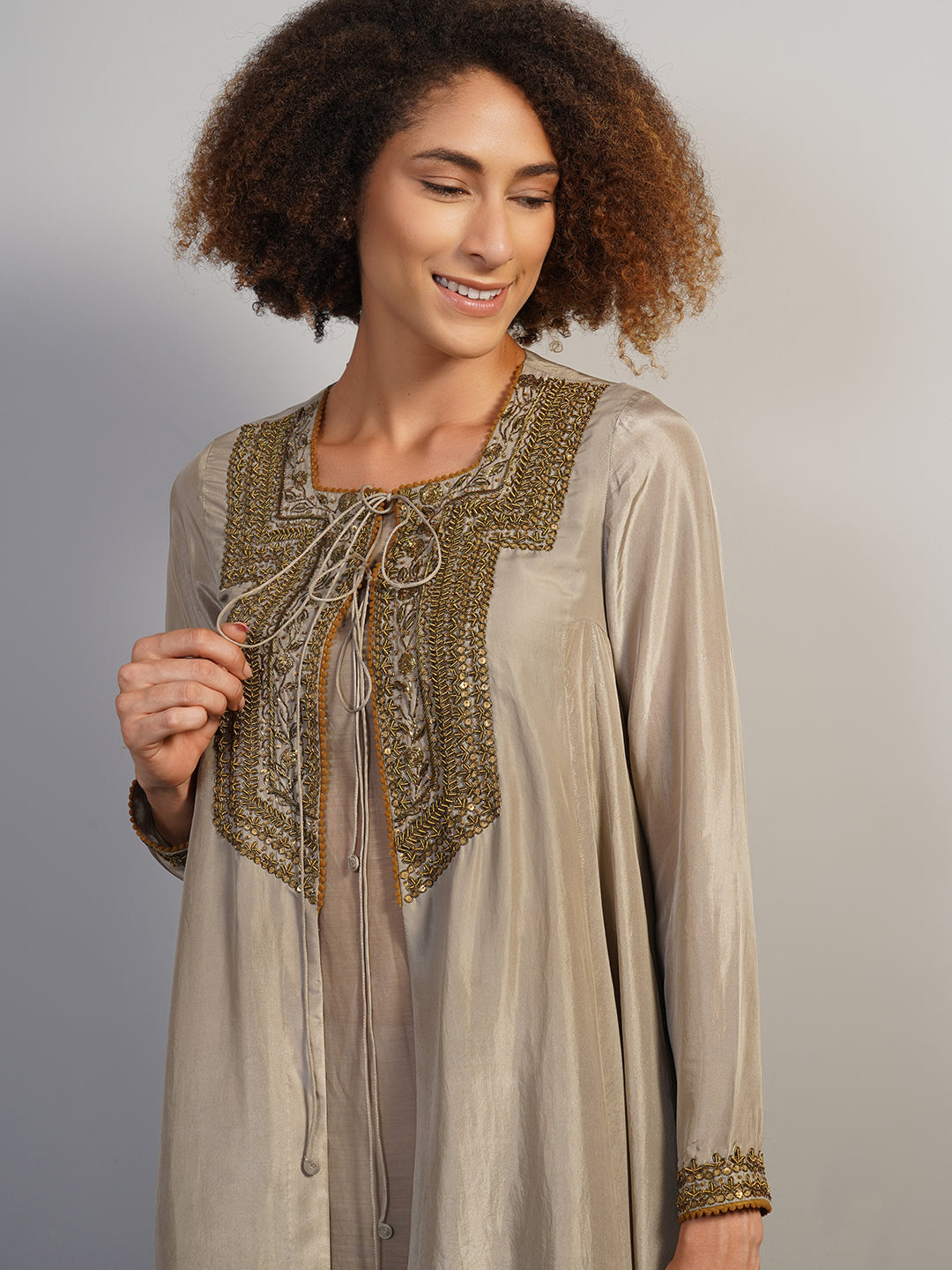 A warm grey silk suit set that is open in the front and secured with a knot at the squared neckline