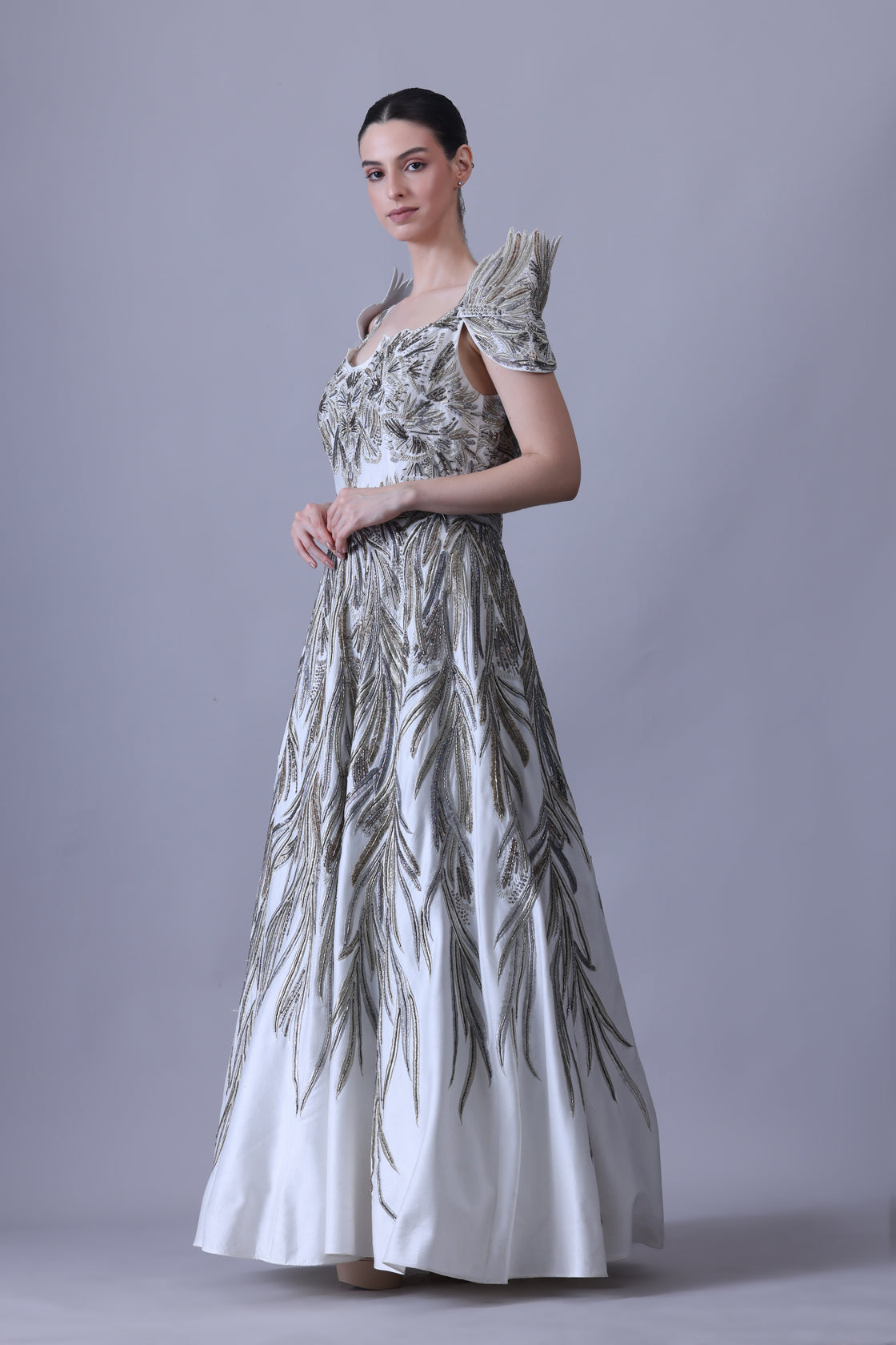 A elegant gown features an off-shoulder design with structured sleeves