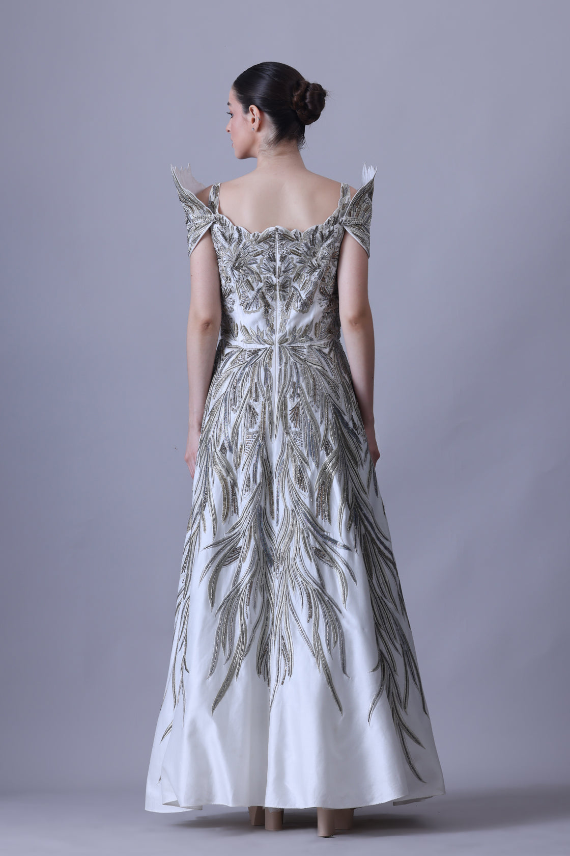 A elegant gown features an off-shoulder design with structured sleeves