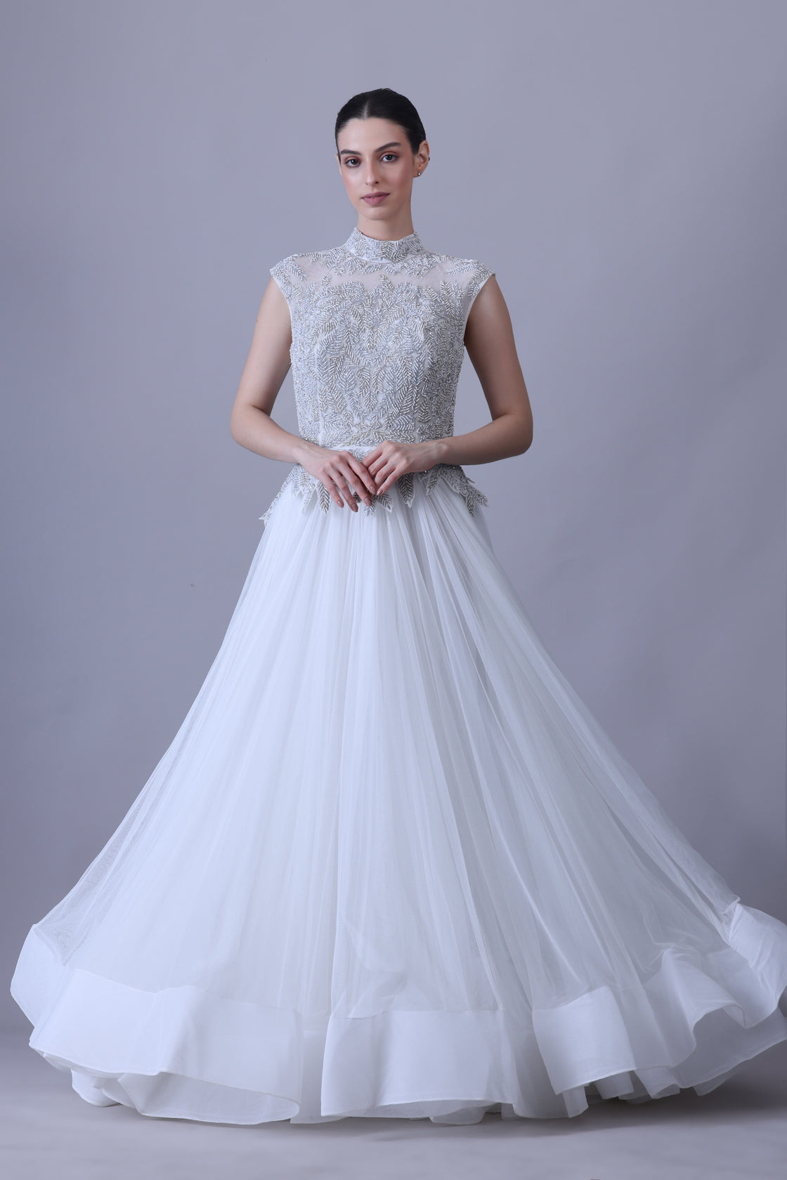 A sleeveless gown features a high-neck embroidered bodice