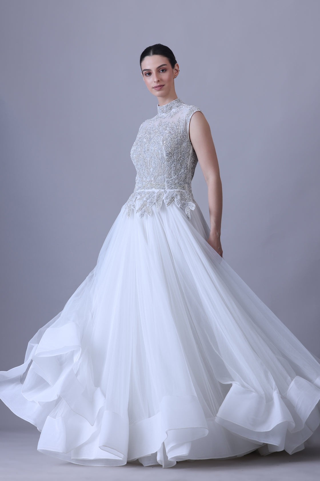 A sleeveless gown features a high-neck embroidered bodice