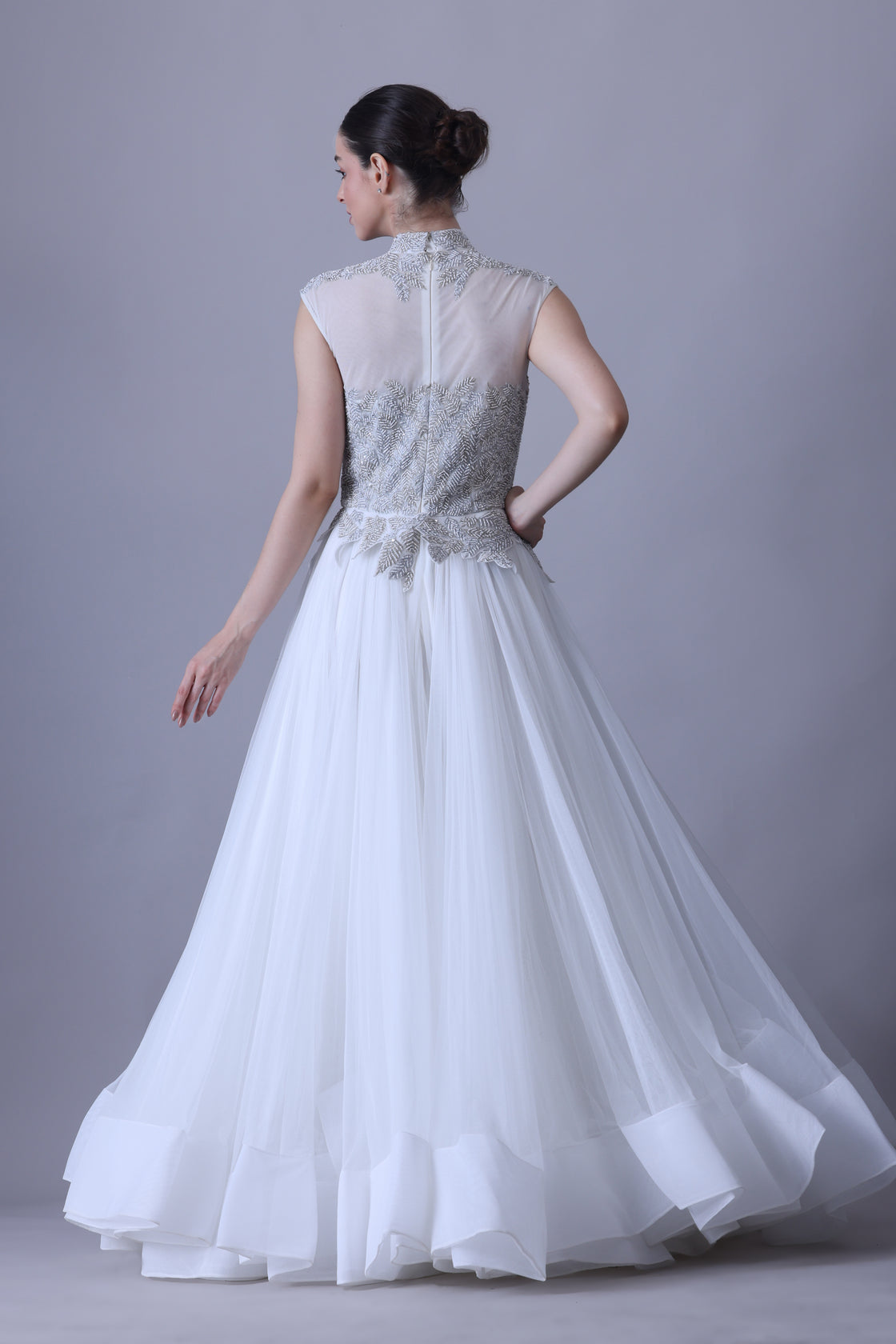 A sleeveless gown features a high-neck embroidered bodice