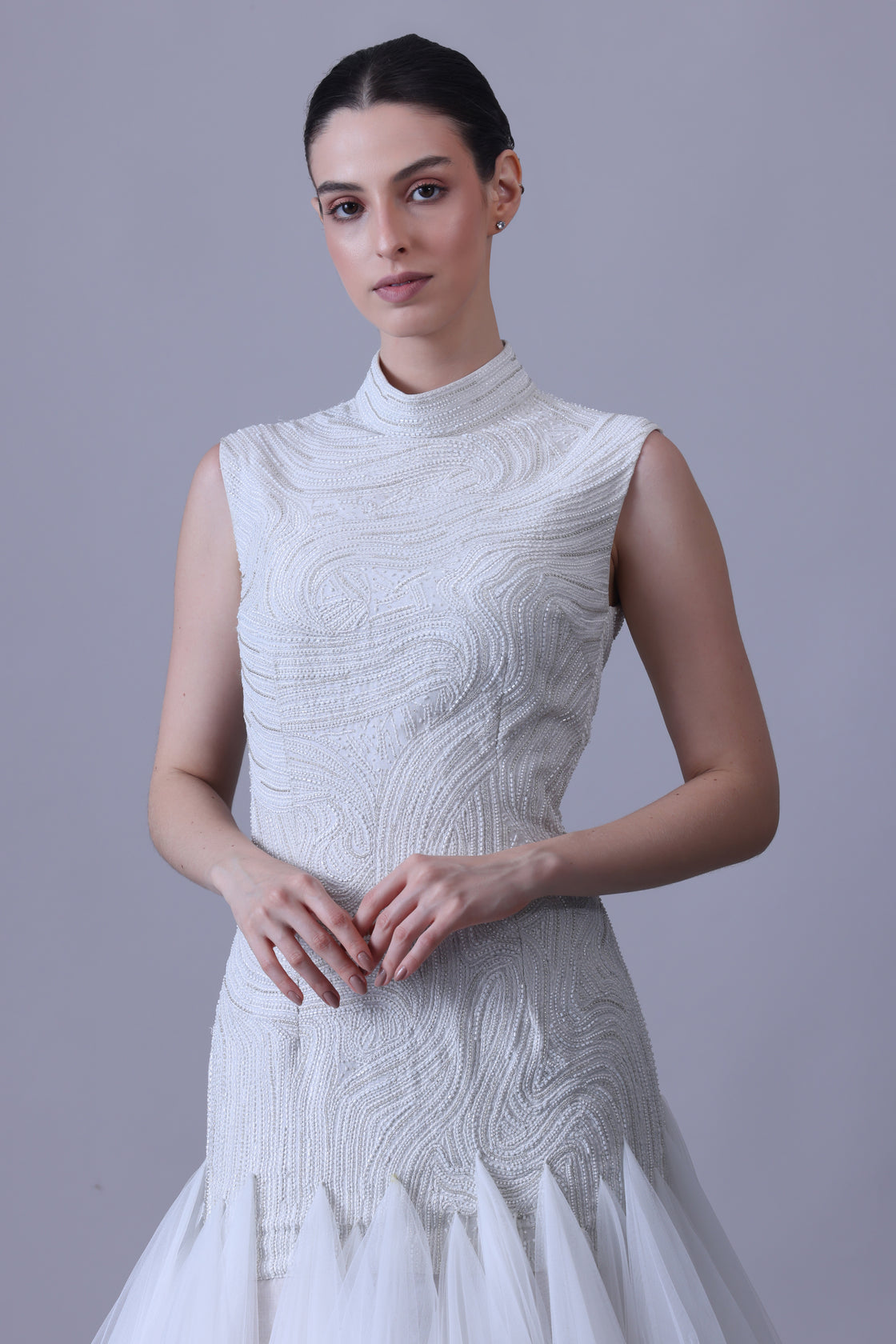 A elegant sleeveless gown features a high neckline and a fitted