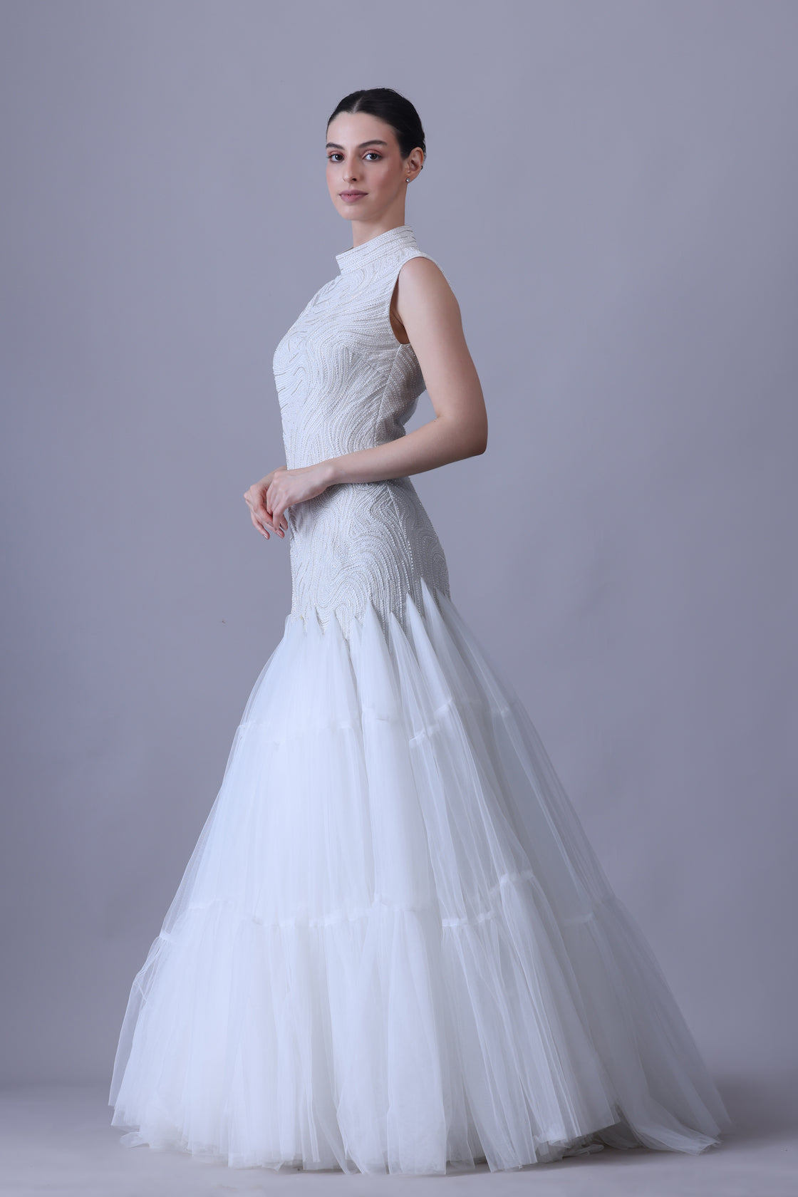 A elegant sleeveless gown features a high neckline and a fitted