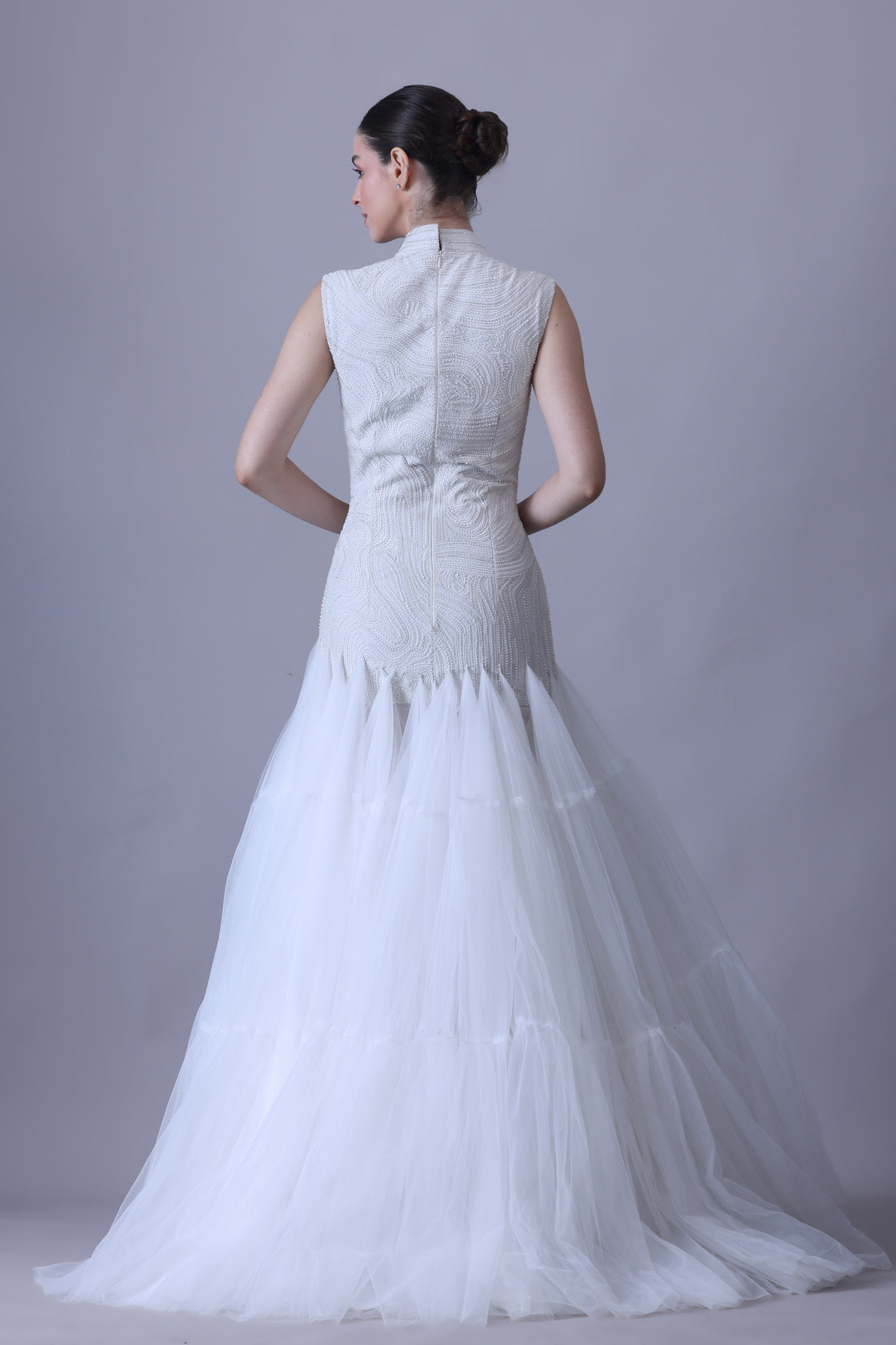 A elegant sleeveless gown features a high neckline and a fitted