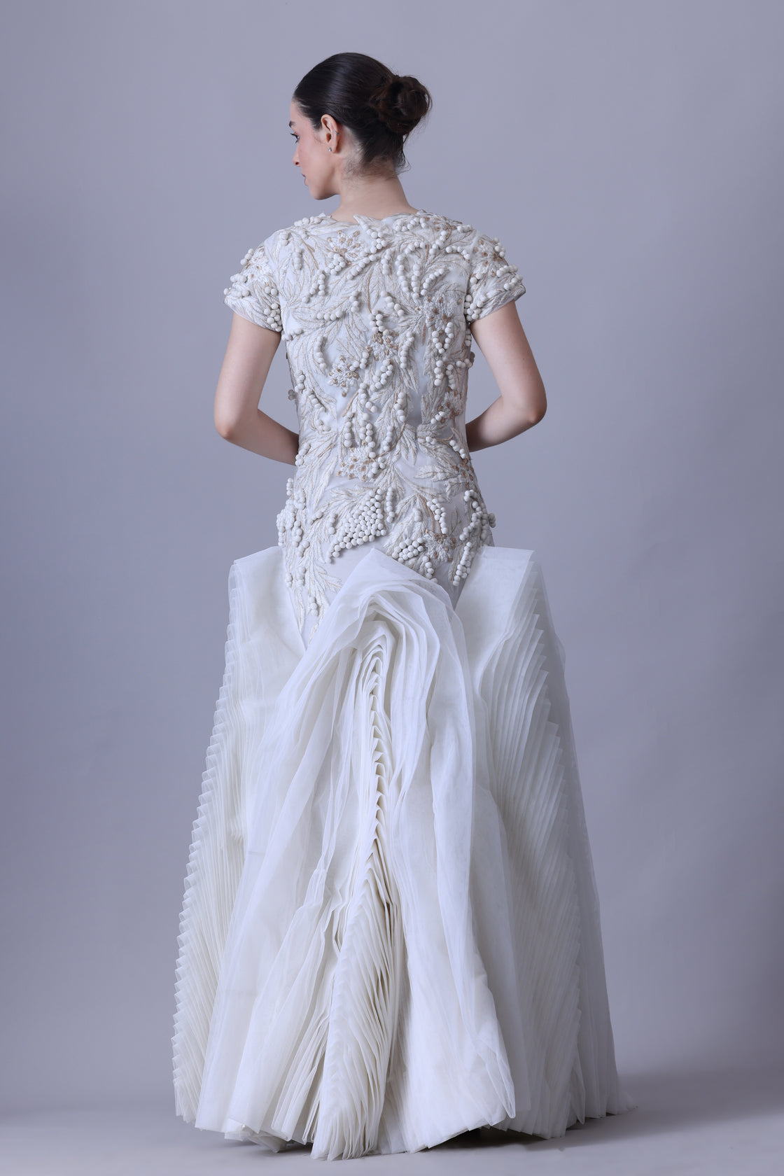 A exquisite gown features a sculpted bodice with ornate bead and thread embroidery
