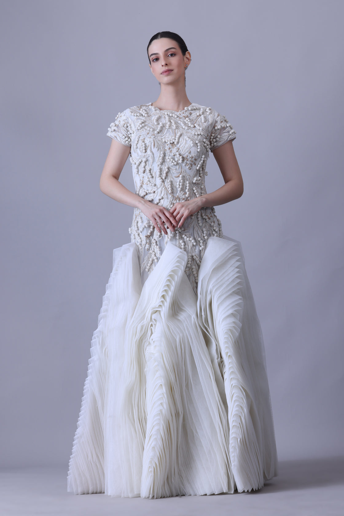 A exquisite gown features a sculpted bodice with ornate bead and thread embroidery