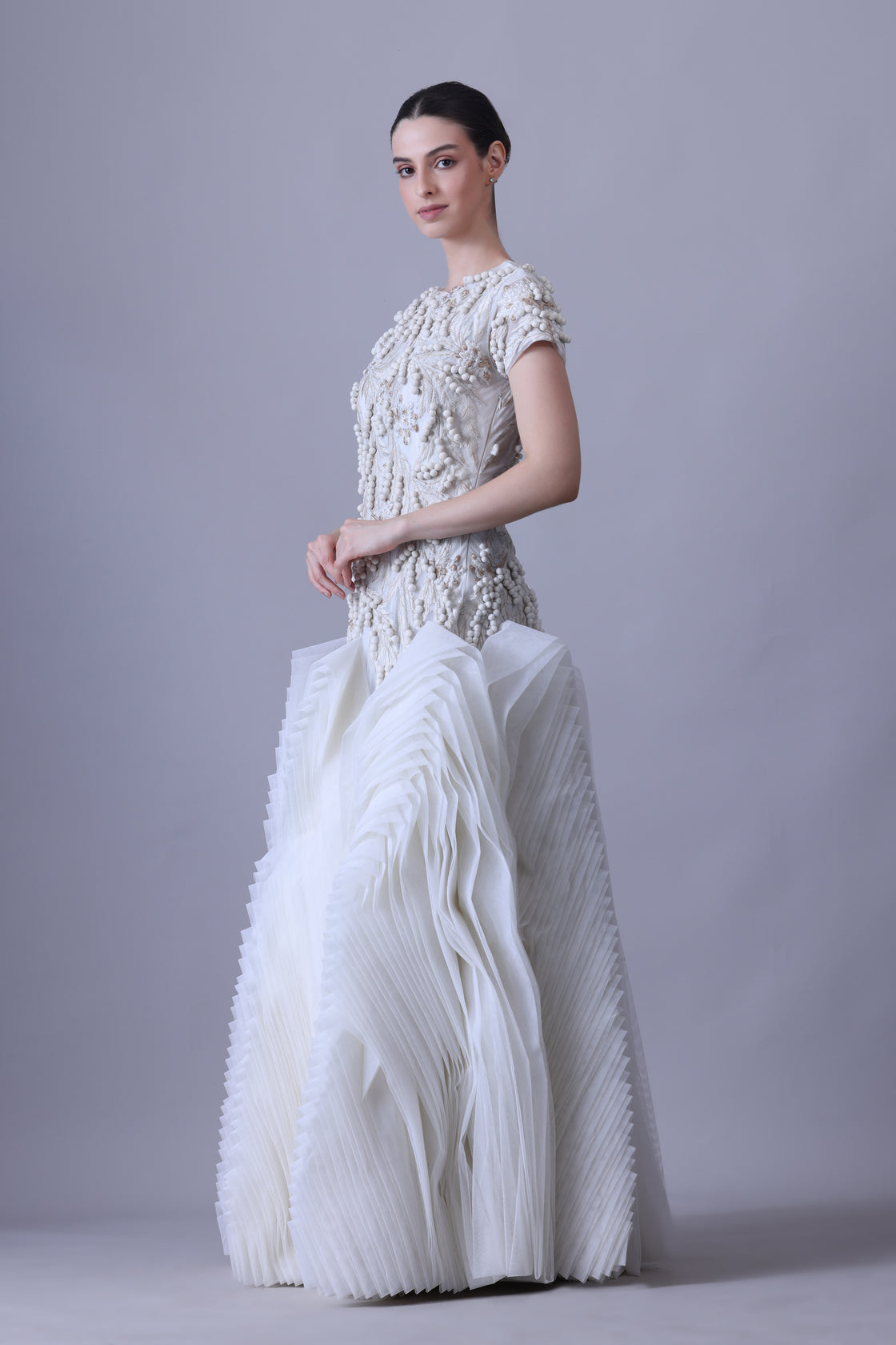 A exquisite gown features a sculpted bodice with ornate bead and thread embroidery