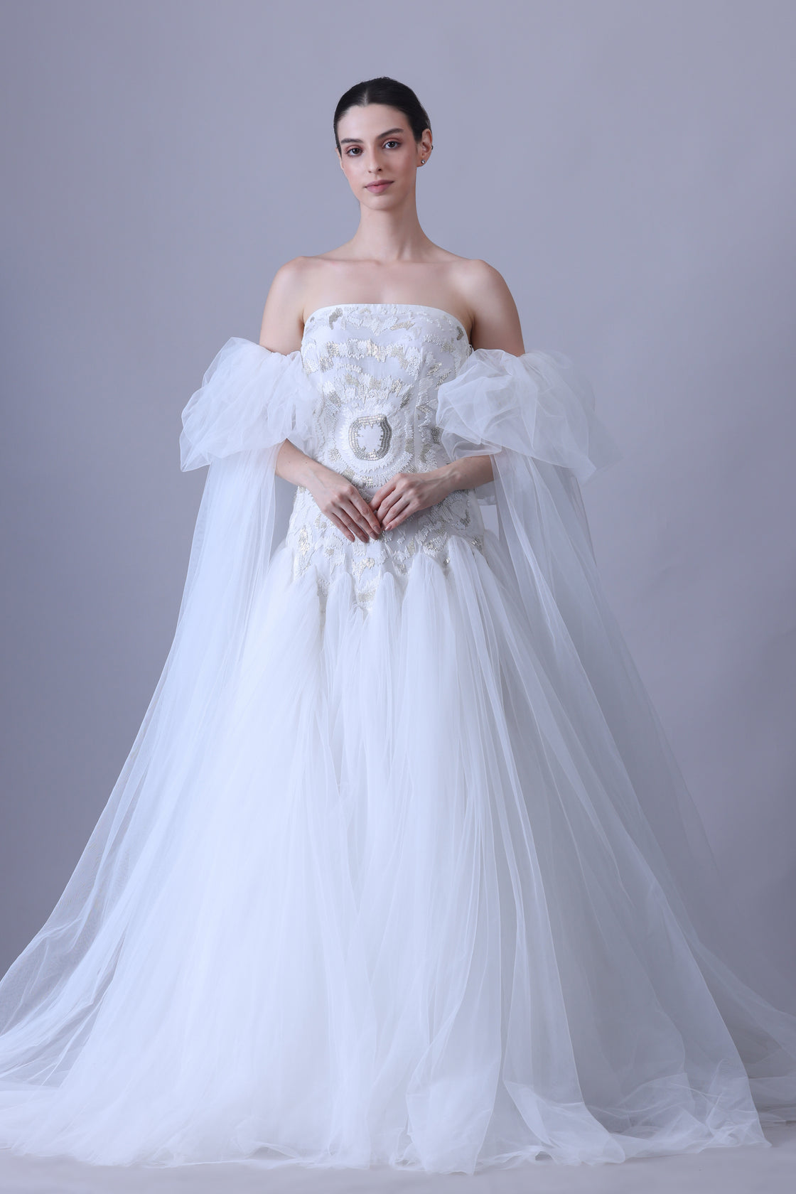 A enchanting off-shoulder gown features a structured embroidered bodice