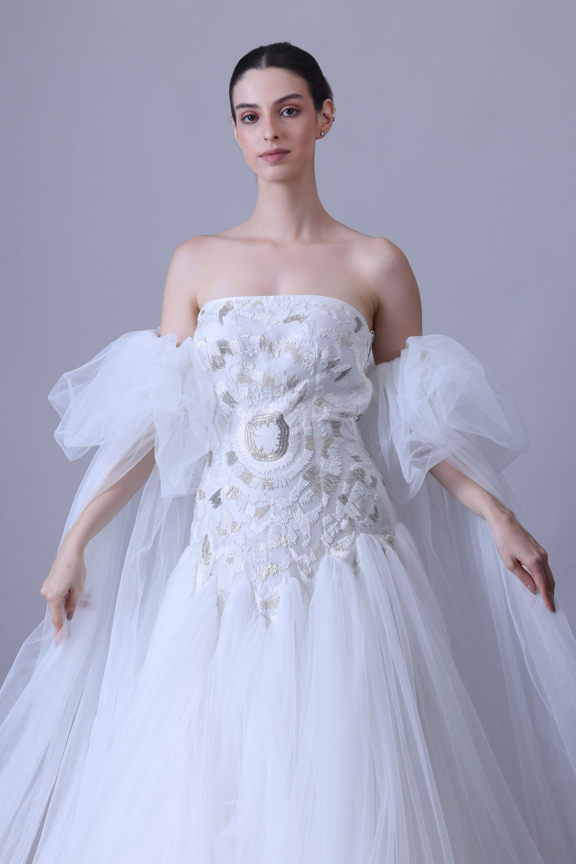 A enchanting off-shoulder gown features a structured embroidered bodice