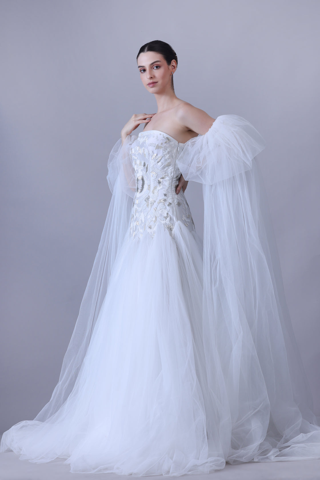 A enchanting off-shoulder gown features a structured embroidered bodice