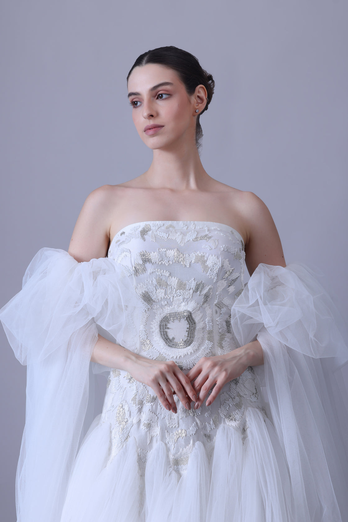 A enchanting off-shoulder gown features a structured embroidered bodice