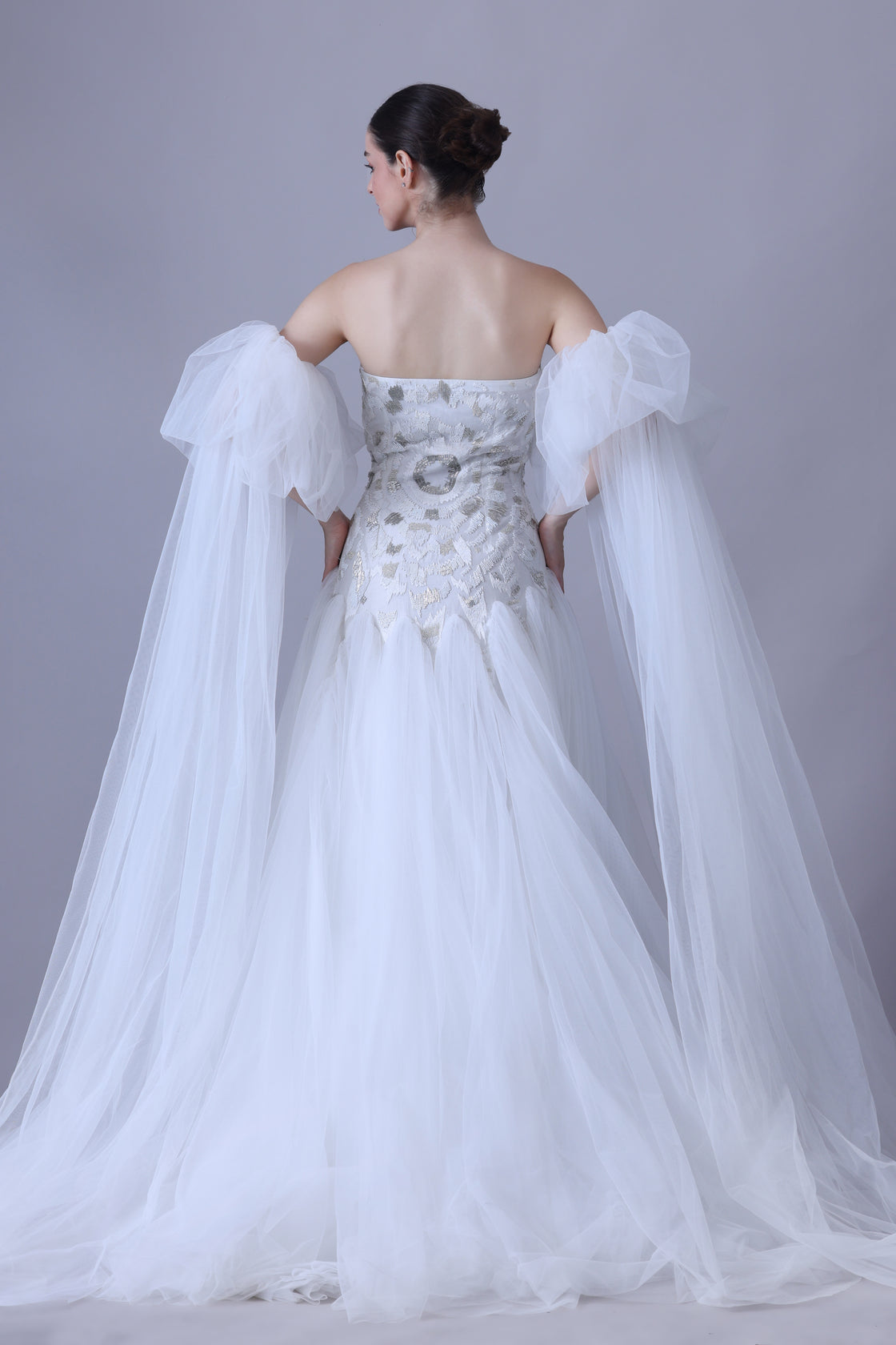 A enchanting off-shoulder gown features a structured embroidered bodice