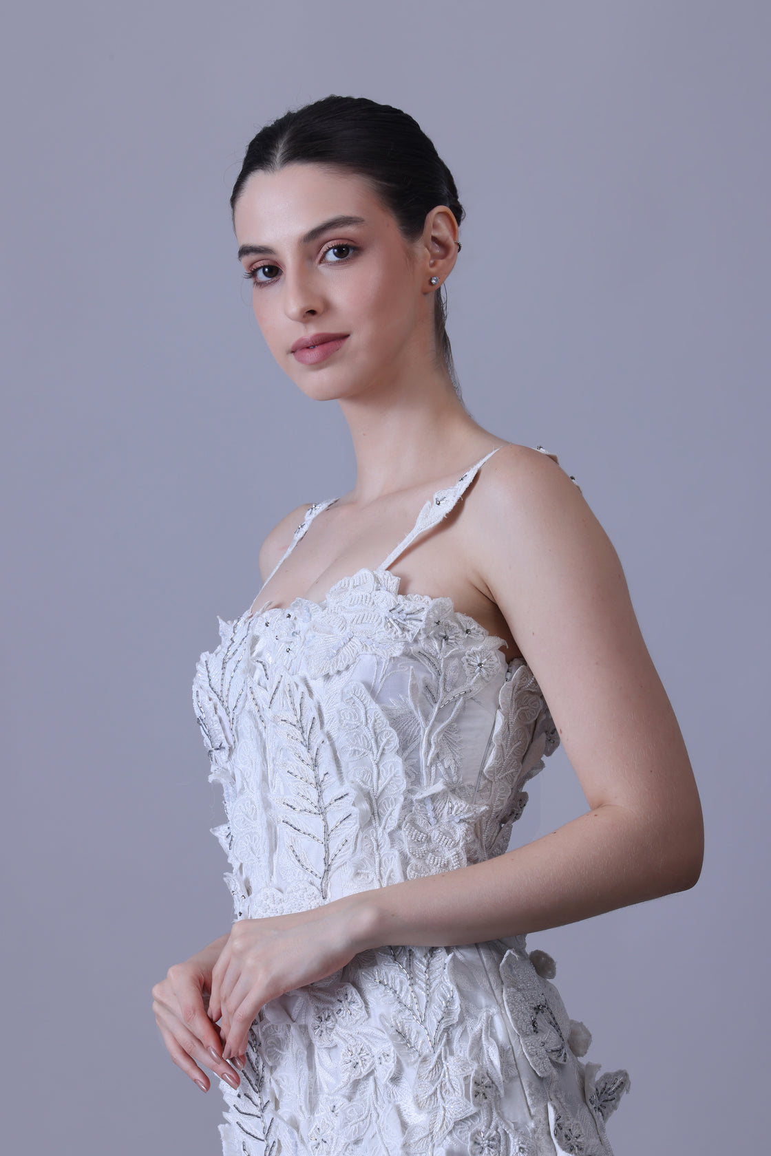 Turn heads in this strappy white gown featuring delicate 3D floral appliqués