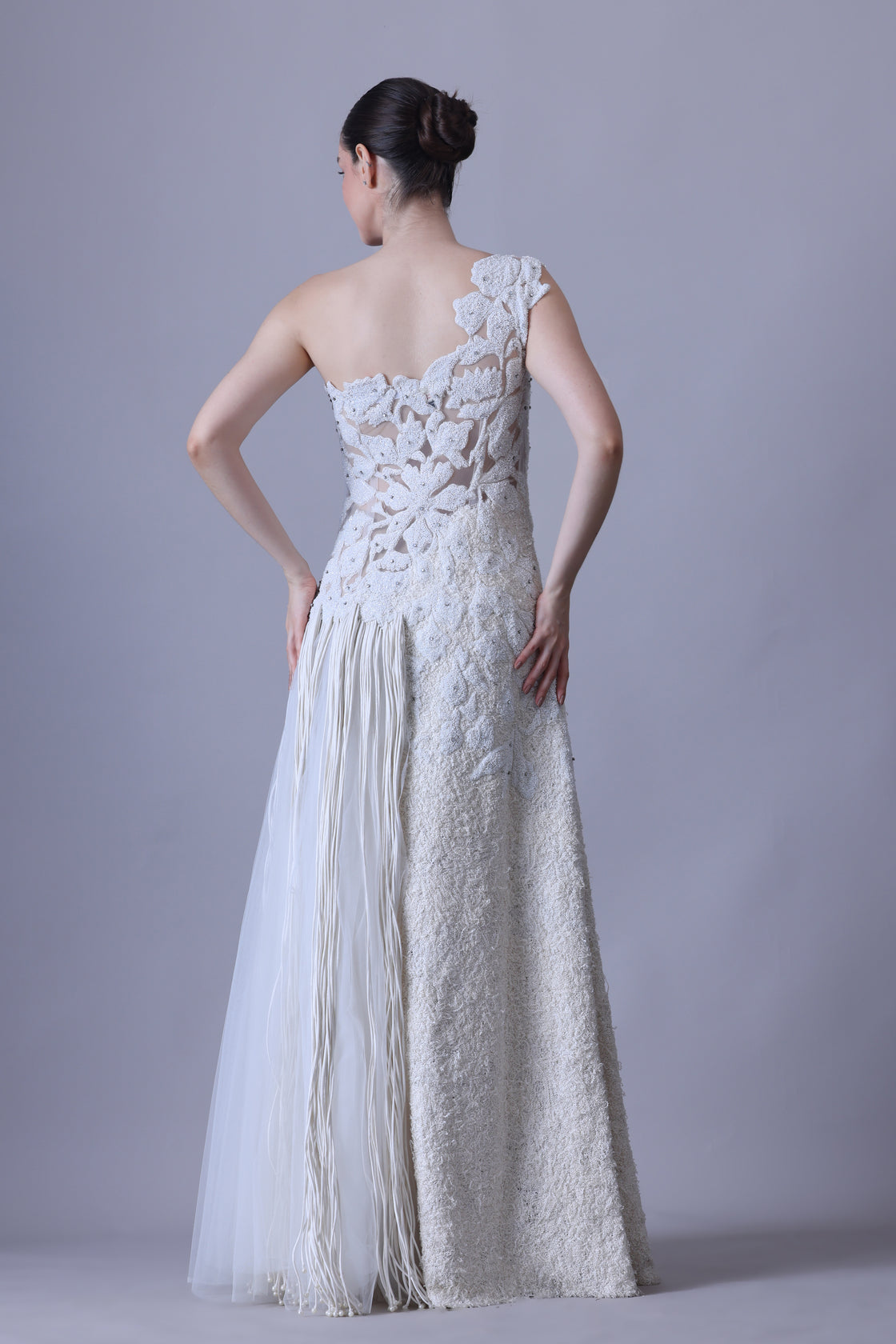 Ivory one-shoulder gown with sheer accents and floral appliqué.