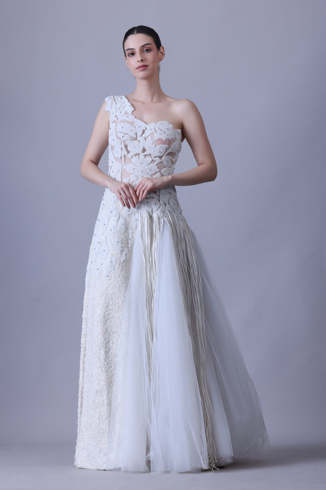 Ivory one-shoulder gown with sheer accents and floral appliqué.