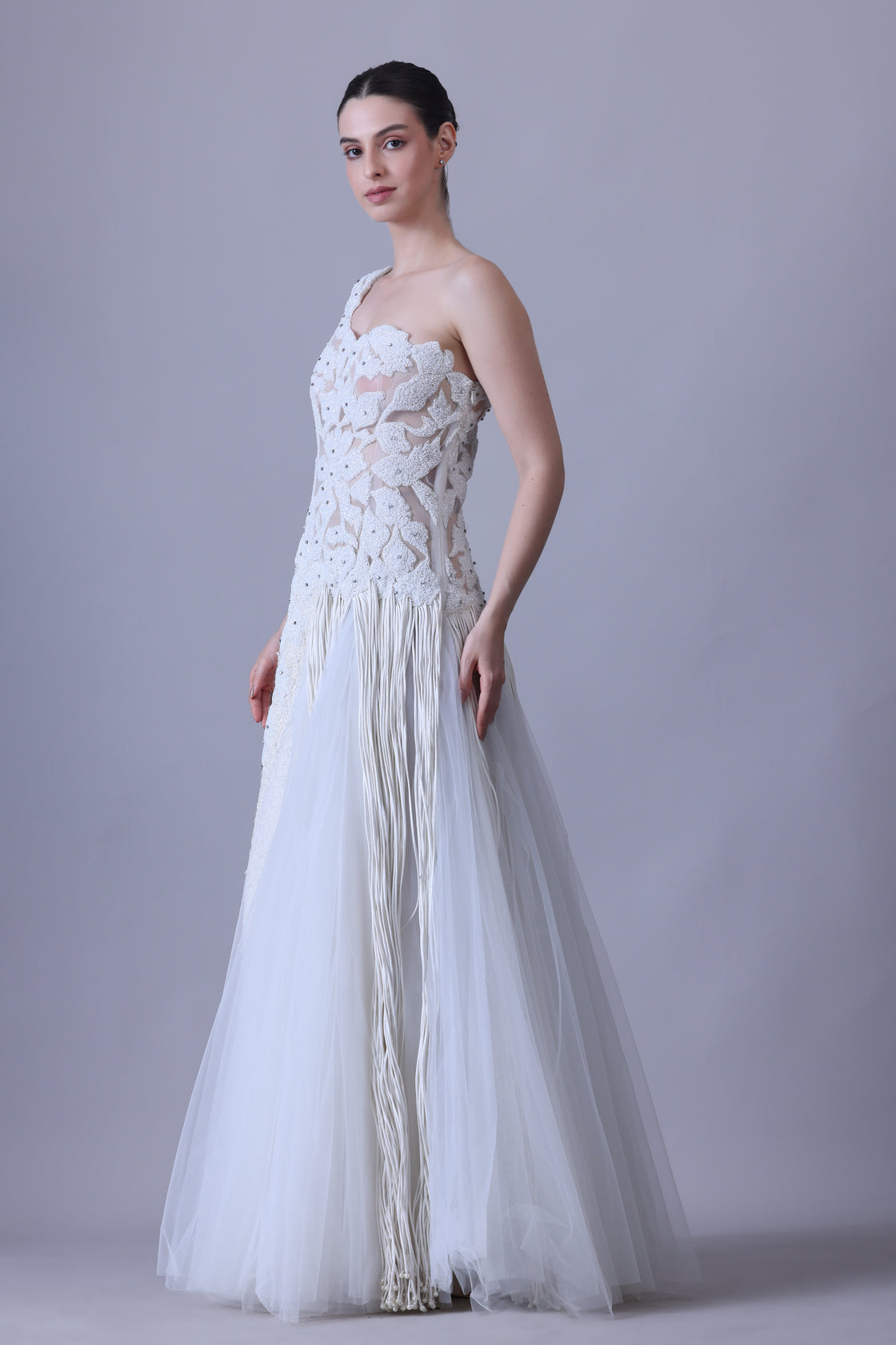 Ivory one-shoulder gown with sheer accents and floral appliqué.