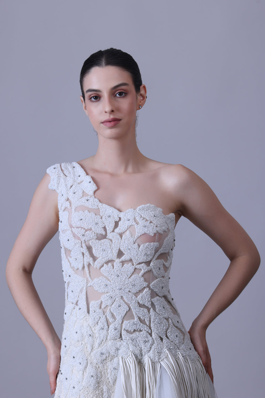 Ivory one-shoulder gown with sheer accents and floral appliqué.