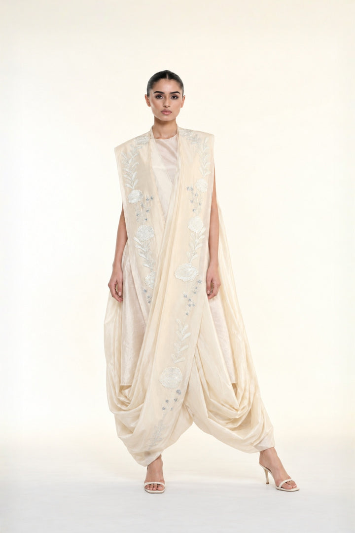 Ivory embroidered draped ensemble featuring floral threadwork, a fluid cowl silhouette, and contemporary cape-inspired styling