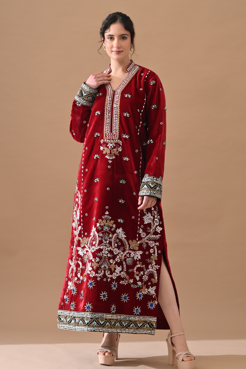 Woman wearing a red embroidered traditional outfit on a beige background