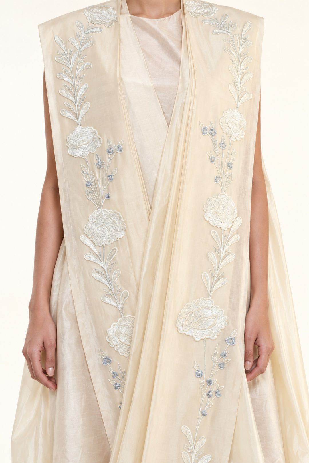 Ivory embroidered draped ensemble featuring floral threadwork, a fluid cowl silhouette, and contemporary cape-inspired styling