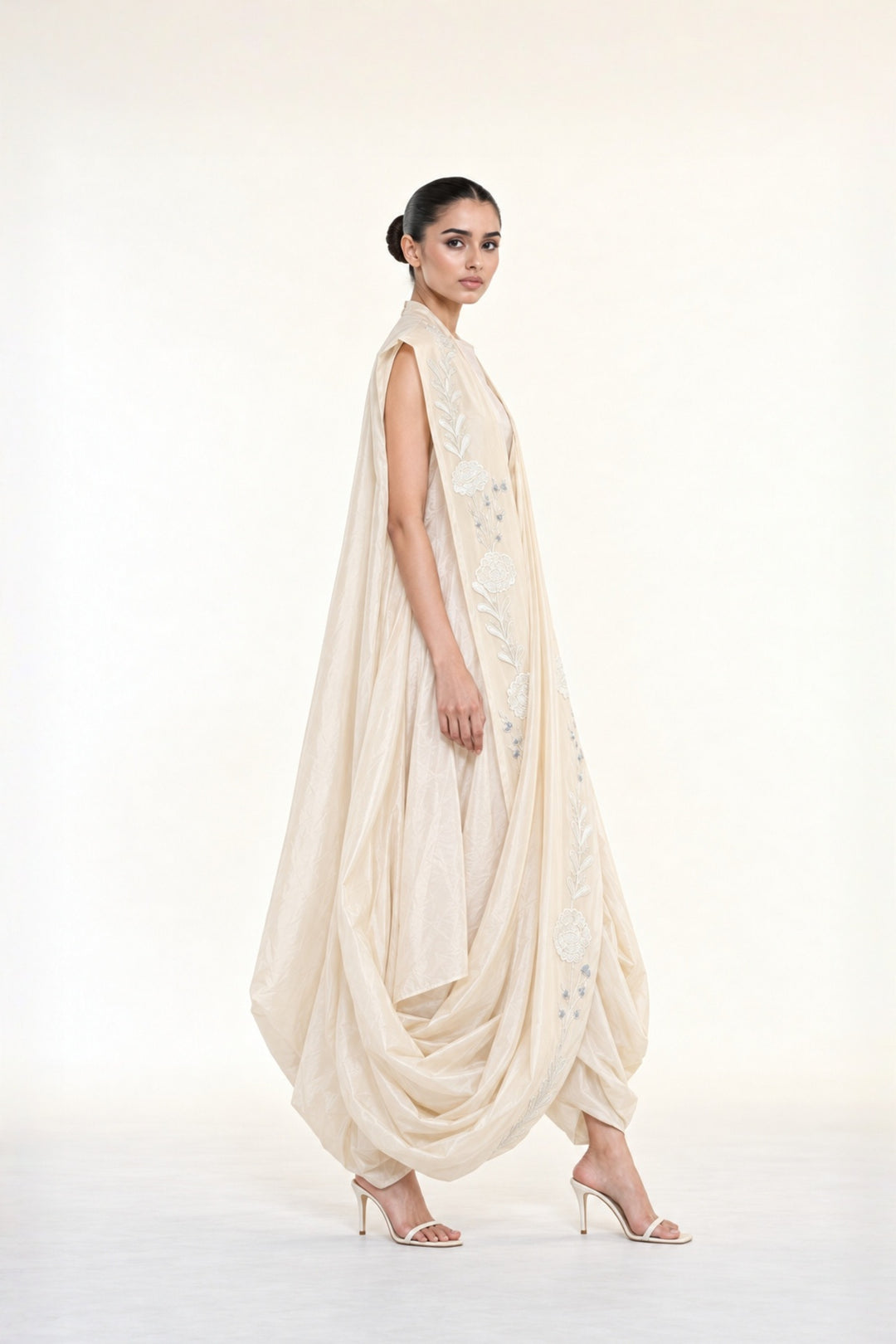 Ivory embroidered draped ensemble featuring floral threadwork, a fluid cowl silhouette, and contemporary cape-inspired styling