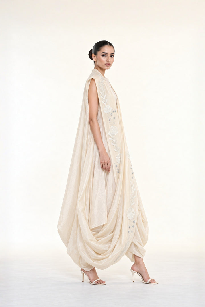 Ivory embroidered draped ensemble featuring floral threadwork, a fluid cowl silhouette, and contemporary cape-inspired styling