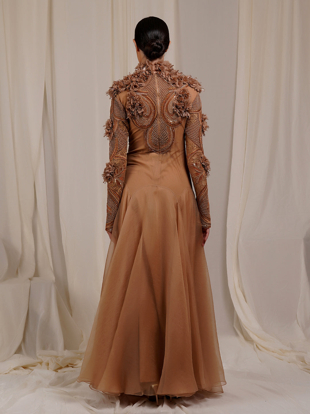 A  beige organza silk floor length gown with high neck line
