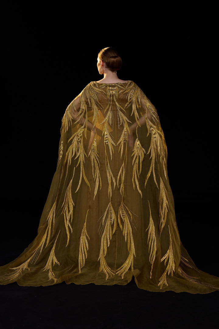 Golden-Bronze Embroidered Gown With Sheer Cape Sleeves , Structured Bodice And Flowy Pleated Bottom.