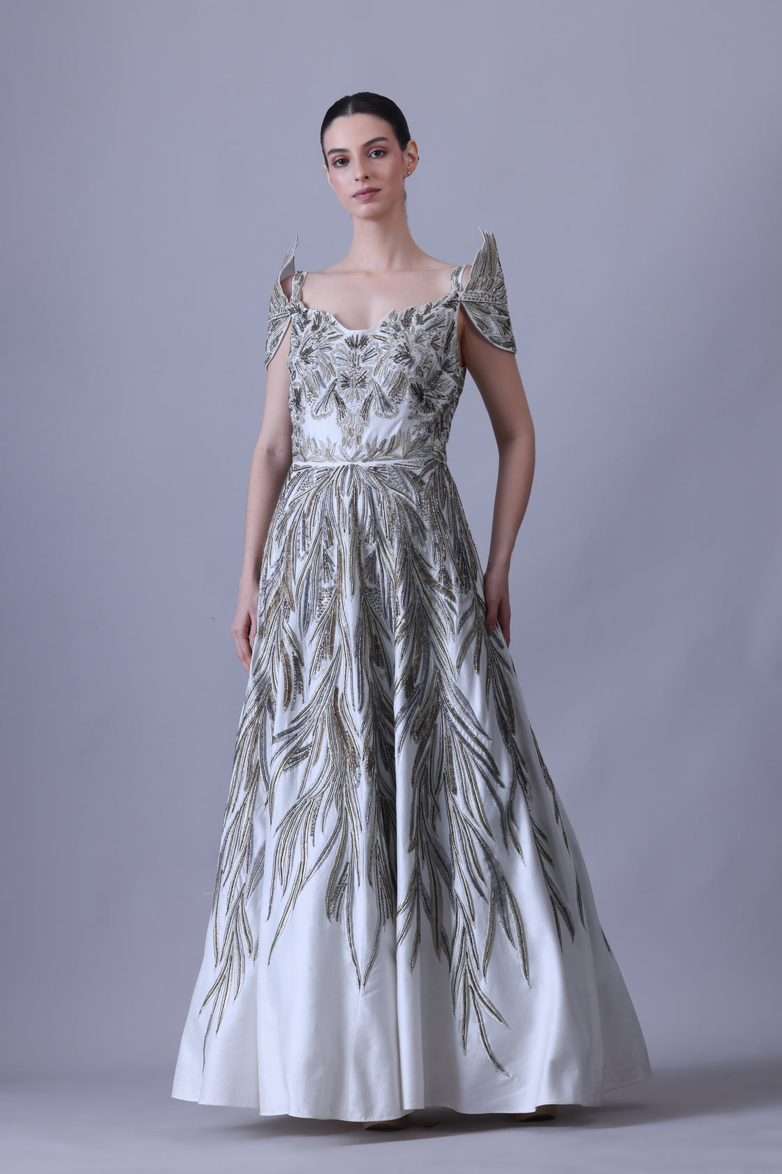 A elegant gown features an off-shoulder design with structured sleeves