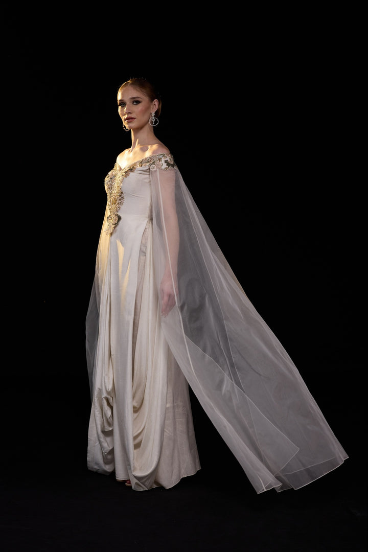 Ivory Off-Shoulder Gown With Floral Embroidery, Sheer Cape Sleeves And A Fluid Floor Length Silhouette