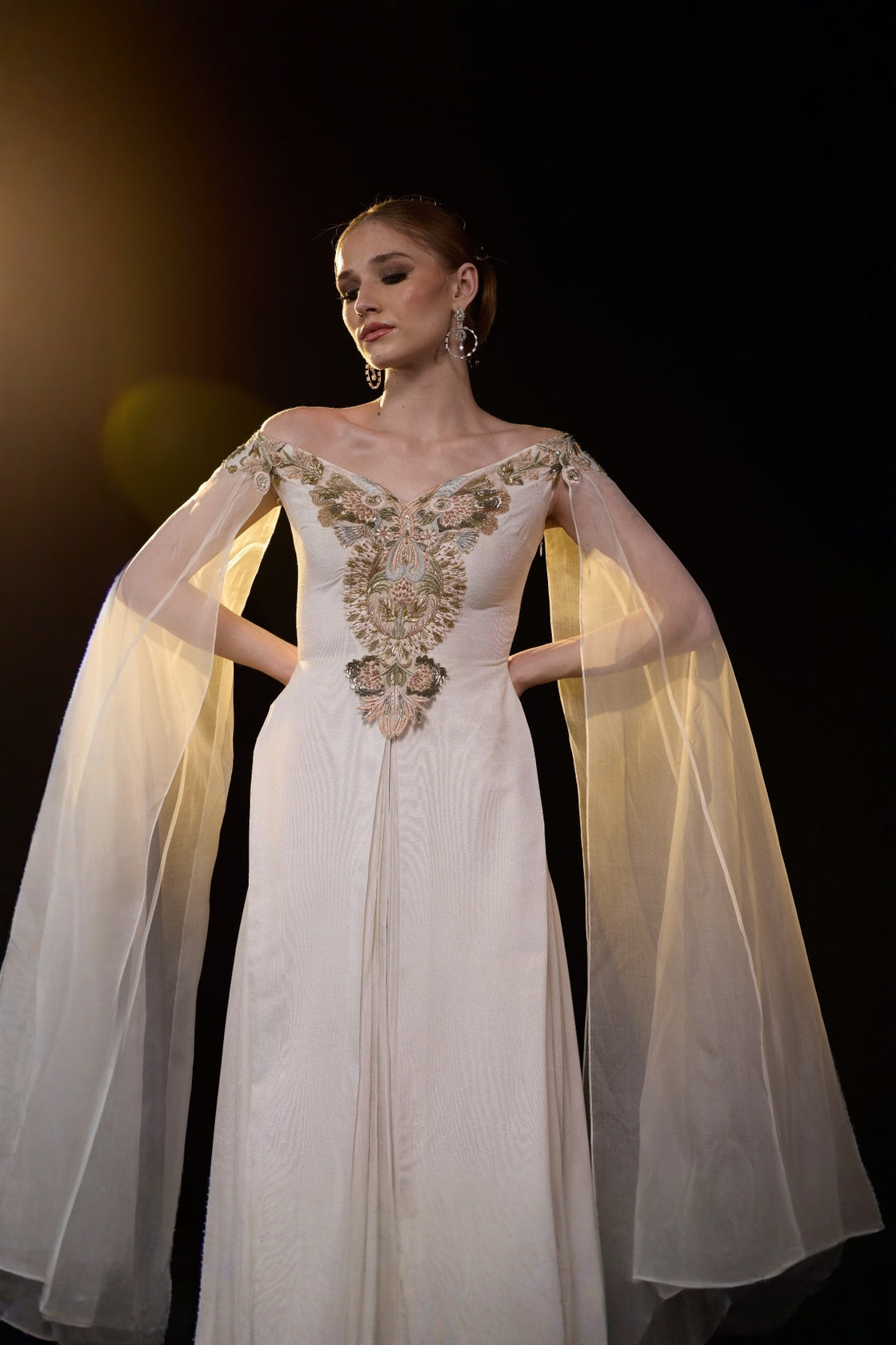 Ivory Off-Shoulder Gown With Floral Embroidery, Sheer Cape Sleeves And A Fluid Floor Length Silhouette