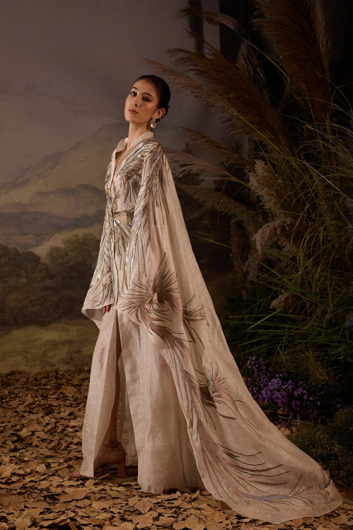 Ivory Embroidered Cape Dress With A V-Neckline , Flowing Draped Sleeves And Intricate Metallic Detailing