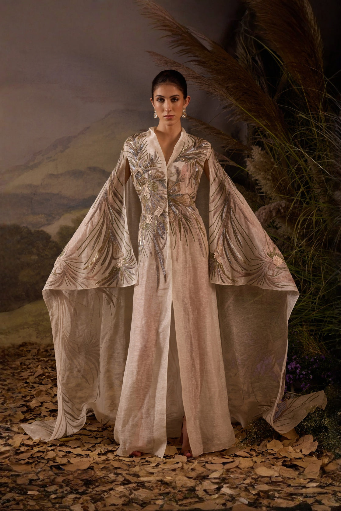 Ivory Embroidered Cape Dress With A V-Neckline , Flowing Draped Sleeves And Intricate Metallic Detailing