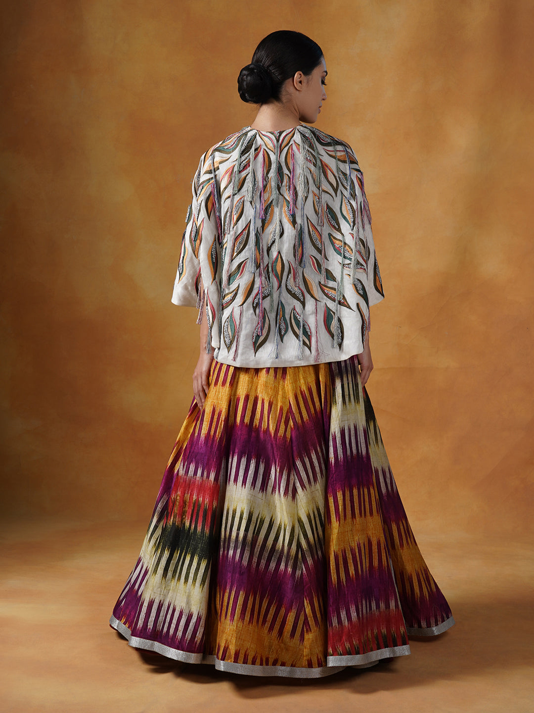 printed cotton silk skirt topped with an off-white cape style waist jacket covered with patchwork with a bustier inside