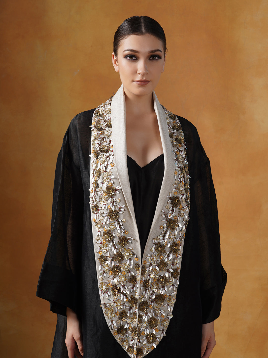 A black floor length lose-fitted gown with an embellished deep yoke neck line.