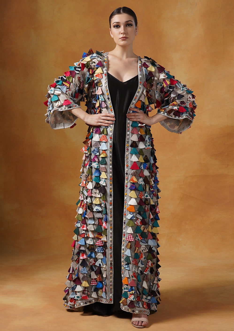 A black cotton silk slip is topped with a cotton silk jacket with colorful tassel art.