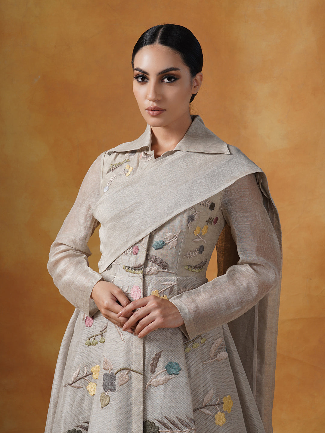 Embroidered A-line linen silk gown which has a collared neck with a pallu that is attached at the waist.