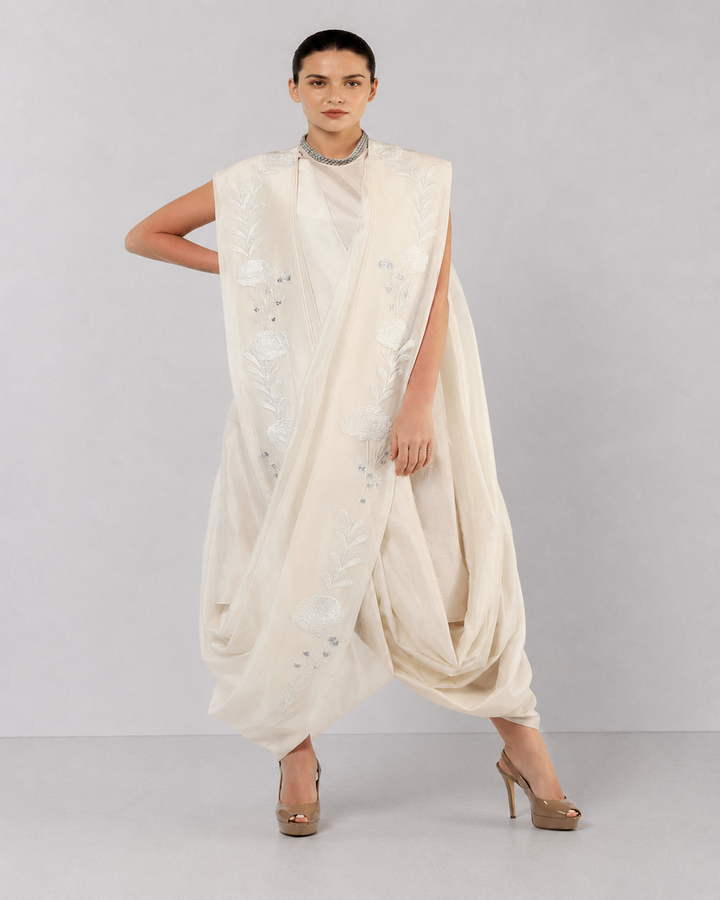 Ivory embroidered draped ensemble featuring floral threadwork, a fluid cowl silhouette, and contemporary cape-inspired styling